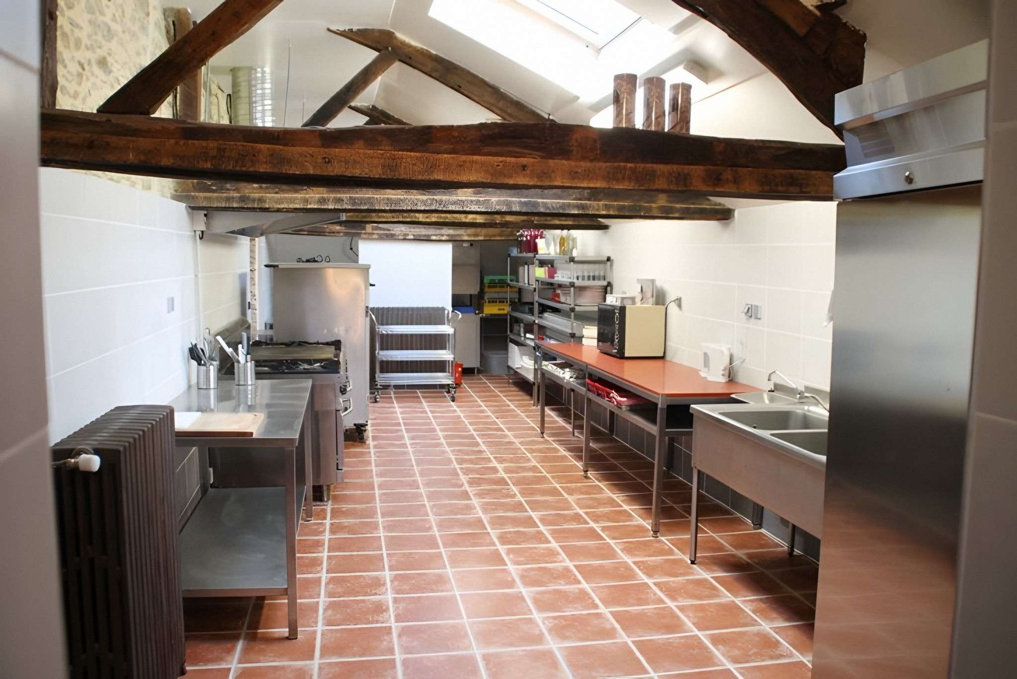 La cuisine du traiteur : plans en inox, fourneaux, chariots et grand évier