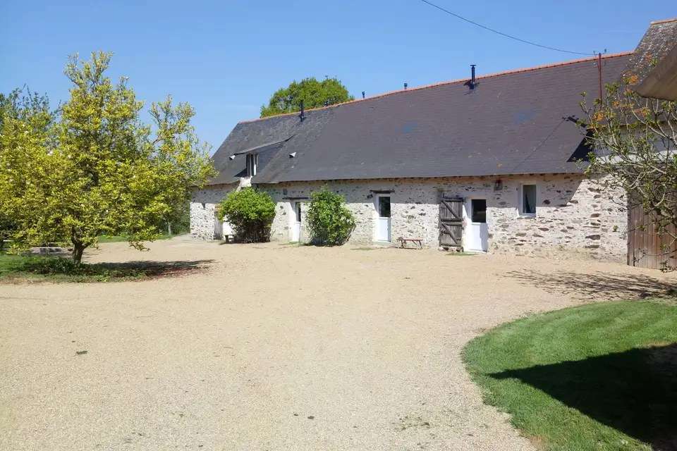 La longère en pierre et la cour de gravier du domaine