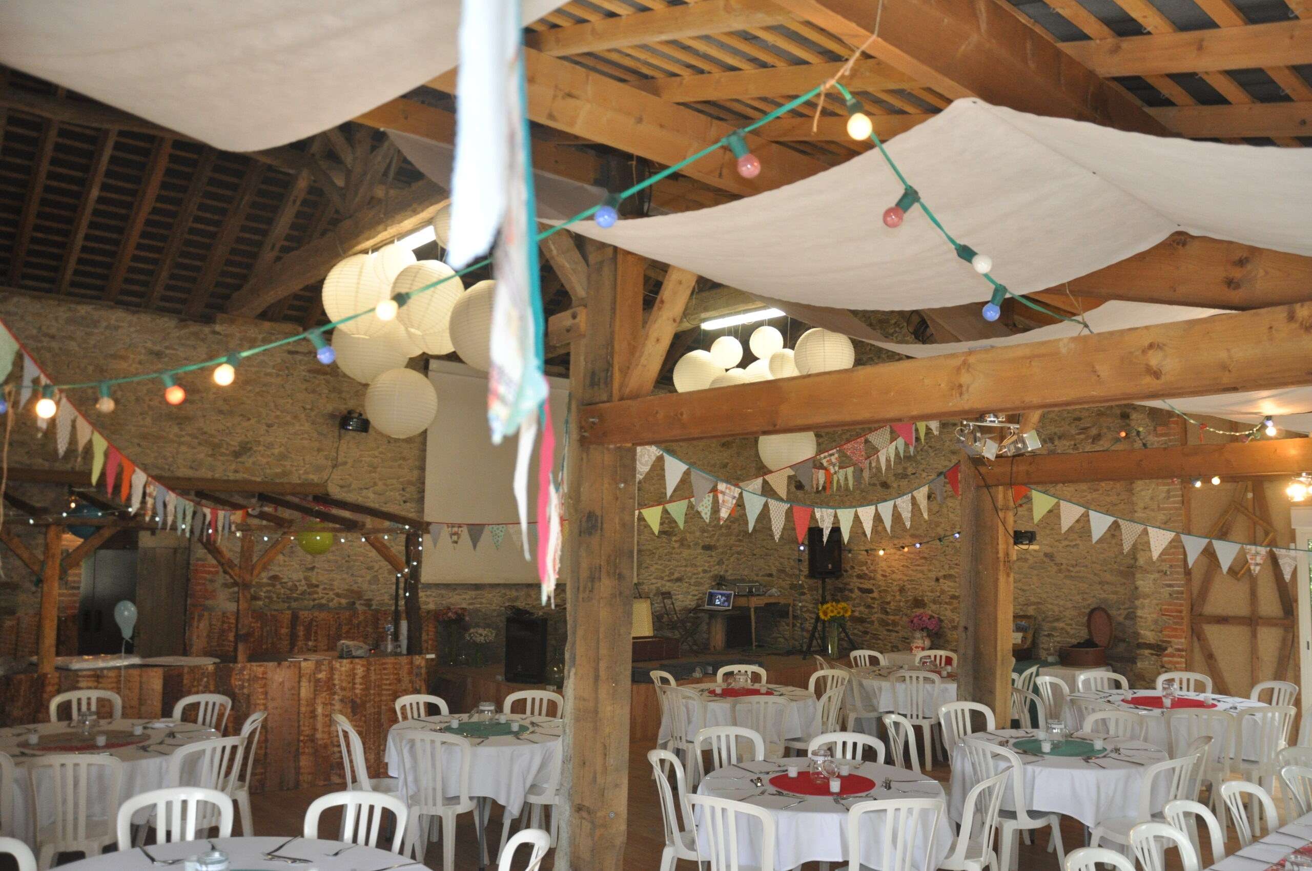 La grande salle en version guinguette : lampions, fanions et tables rondes