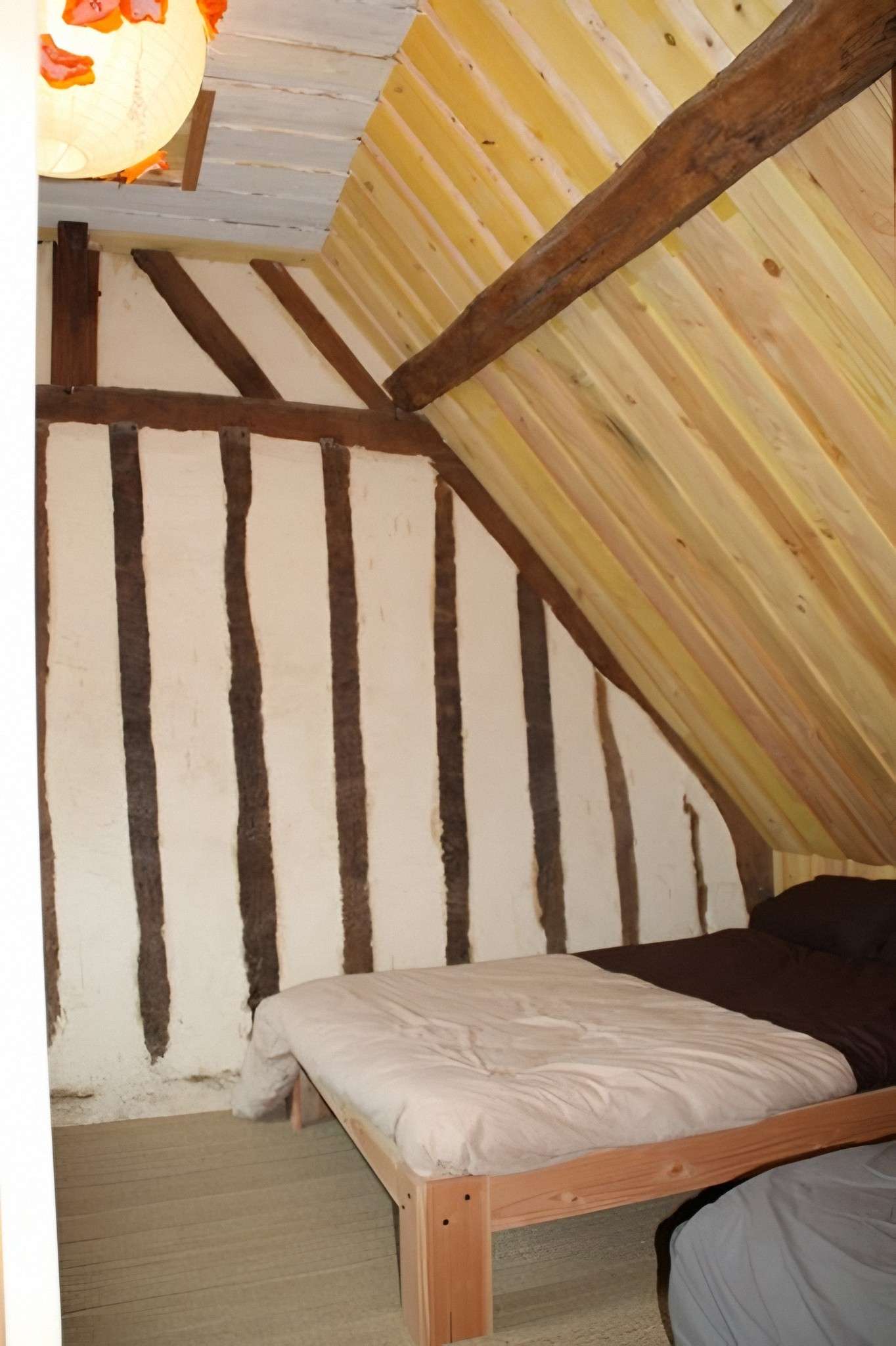 Une chambre du gîte Le Verger, sous la charpente et les colombages